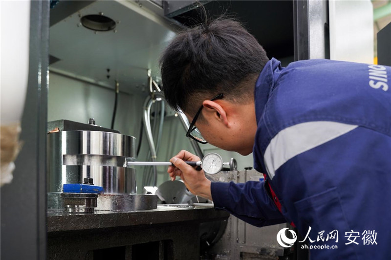 中钢诺泰企业里员工正在用仪器对自动车床制作的零部件进行精密度测试。人民网 王锐摄