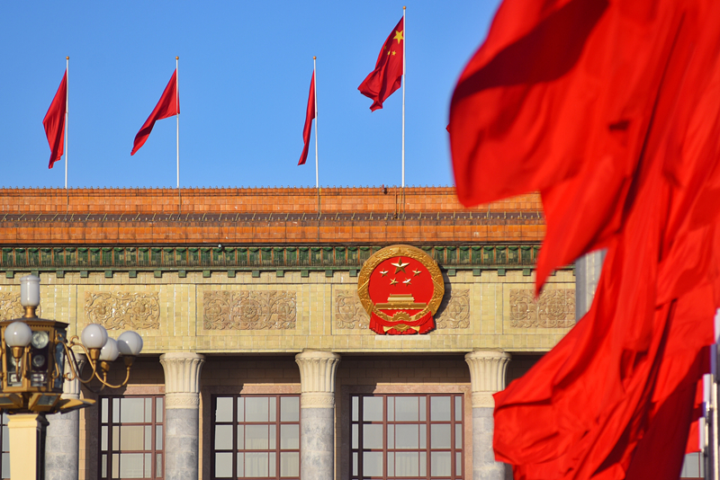 2024年3月8日，北京上空现“两会蓝”，人民大会堂前红旗飘扬。